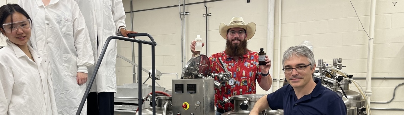 Students standing around a large piece of lab equipment.