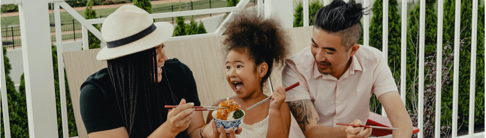 Girl smiling with parents outside. Image by Tyson on Unsplash.