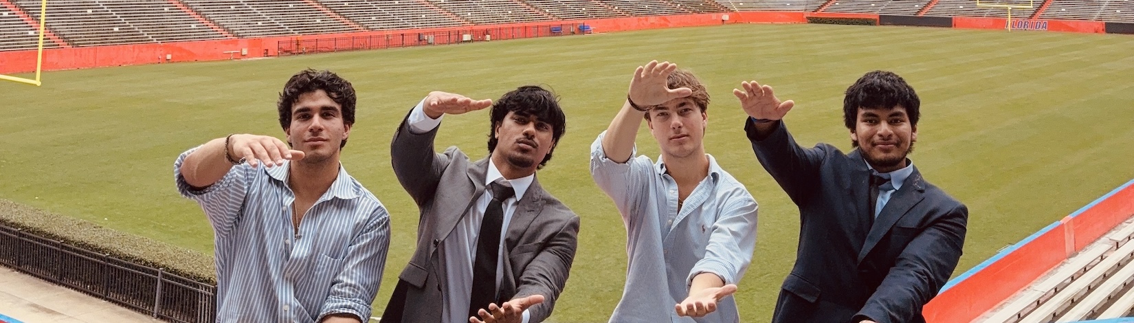 Four college students doing the Gator Chomp in an empty football stadium, dental | Food Science and Human Nutrition UF/IFAS