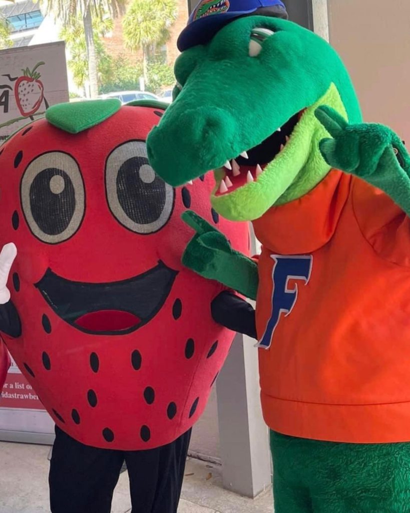 FSGA mascot Jammer (a strawberry) poses with UF mascot Albert (an alligator).