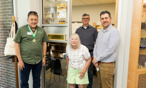 Vera Damron, Dr. Andrew Short, Dr. Jamie Ellis, and Todd Bundy pose with the newly dedicated Damron Family Office at the UF/IFAS Honey Bee Research and Extension Laboratory.
