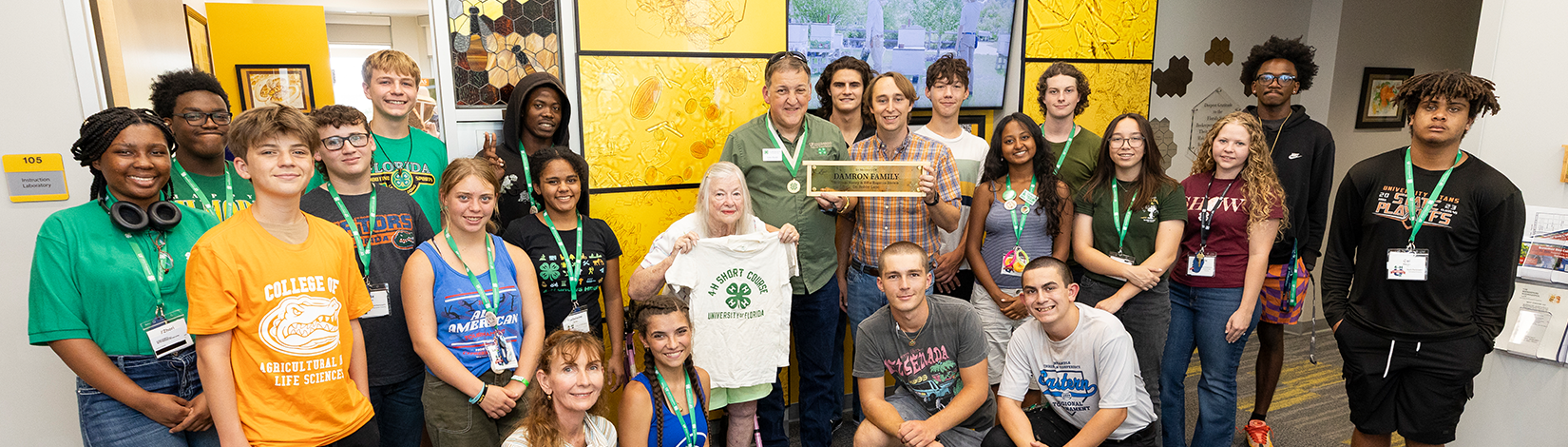 Vera Damron, Todd Bundy, UF/IFAS faculty, and 4-H University students at the Damron Family Office room dedication. They are in the lobby of the UF/IFAS Honey Bee Research and Extension Laboratory.