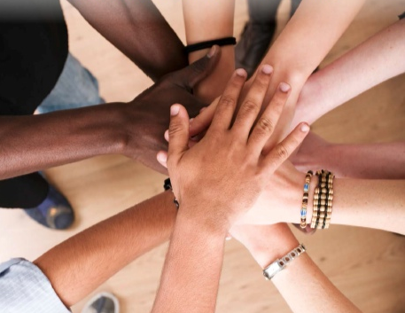 many Hands on top of one another in a huddle