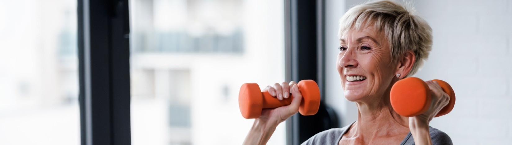 Portrait of senior woman lifting dumbbells.