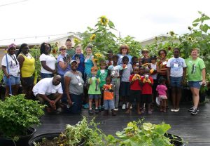 A group of Gardeners pose in their community garden with Master Gardener Volunteers. t th