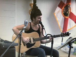 Local Guirtarist and singer sits and plays at the microphone at last Years Garden Festival