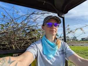 woman and tree debris in gator utility vehicle