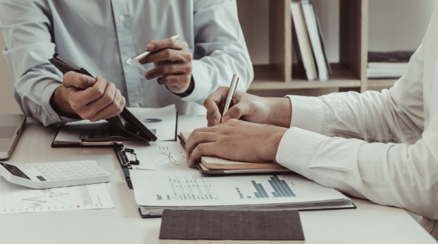 2 people discussing and sitting next to laptops