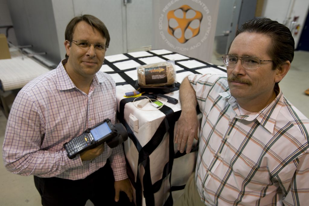 Jean-Pierre Émond (left) wears a pink button-up and holds a scanner in a lab. Dr. Jeffrey Brecht (right). Both are co-founders of the UF/IFAS Center for Food Distribution and Retailing. Photo taken April 1, 2009.