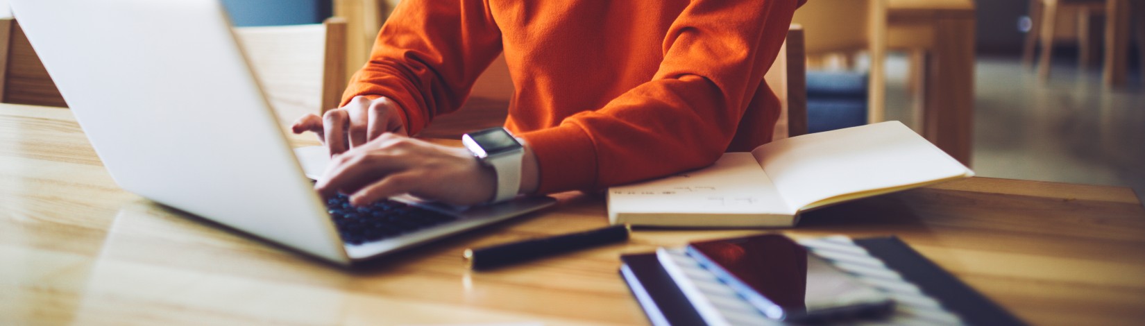 Professional young copywriter in trendy eyewear working on creation advertising content typing on laptop computer connected to wireless internet, skilled journalist browsing information in web site.