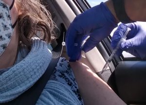 Woman getting vaccination shot in arm