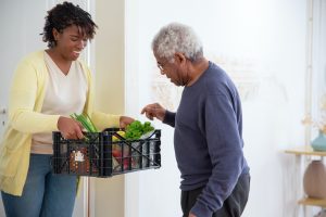 a woman hands a basket of food to a man