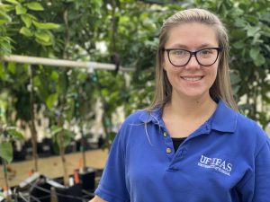 Dr. Flavia Zambon works in a greenhouse with citrus nursery trees for the MAC project