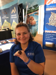 Intern with beetle at outreach event 