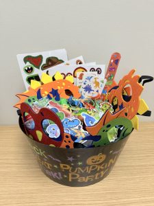 A bowl of Halloween non-food items such as masks and stickers