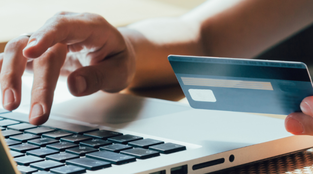 girl makes a purchase on the Internet on the computer with credit card
