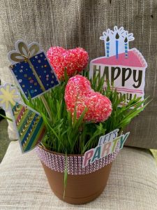 planted container with happy birthday signs