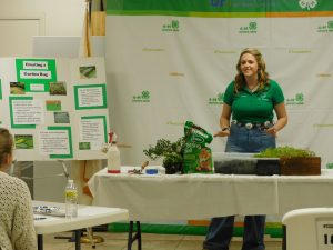 4-H member giving a demonstration about landscaping using garden rugs. 