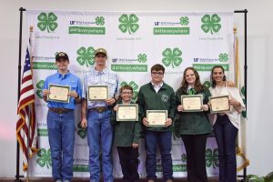 4-H members posing for a picture with certificates.