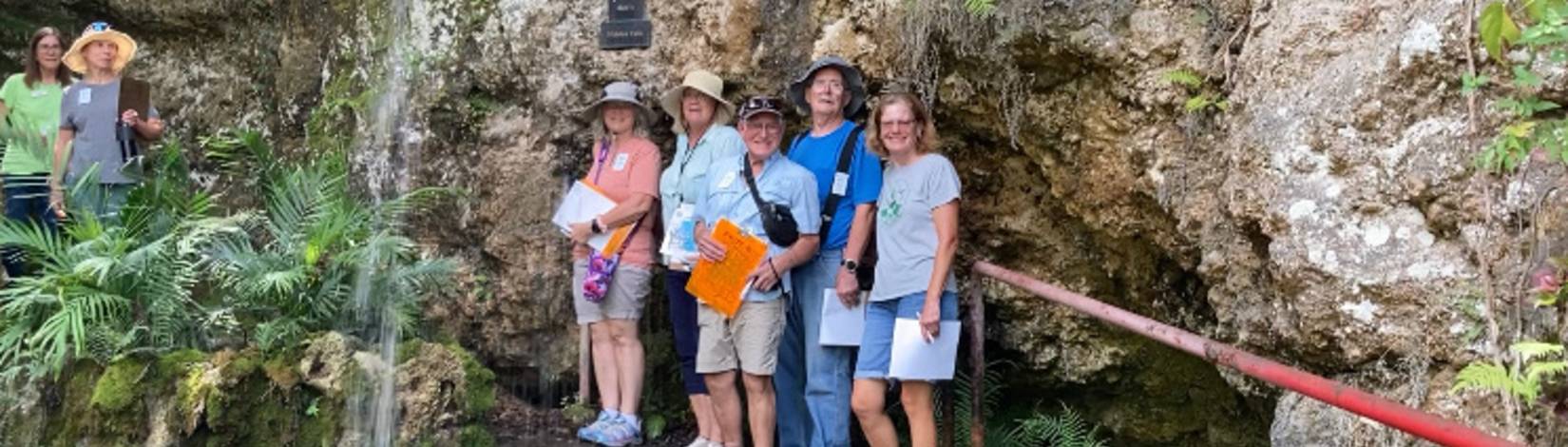 people standing behind a waterfall