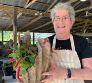 woman holding a container of flowers