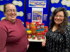 two smiling women on each side of peanut butter display