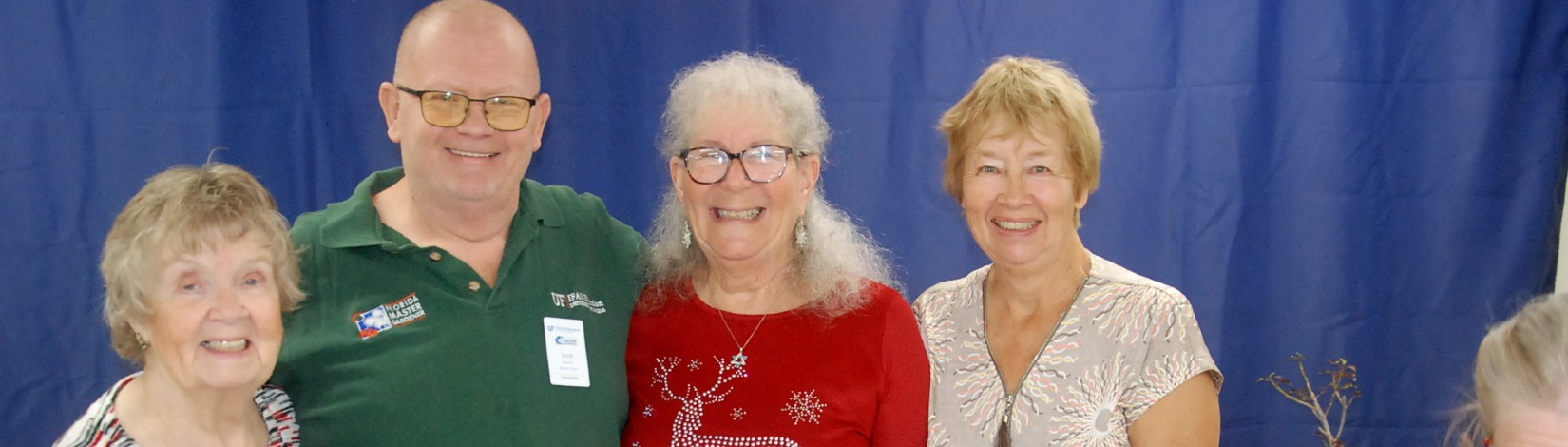 four people stand in front of blue banner