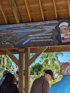 Visitors to the Ripple project stand beneath a gazebo with a pictorial and narrative history of the project.