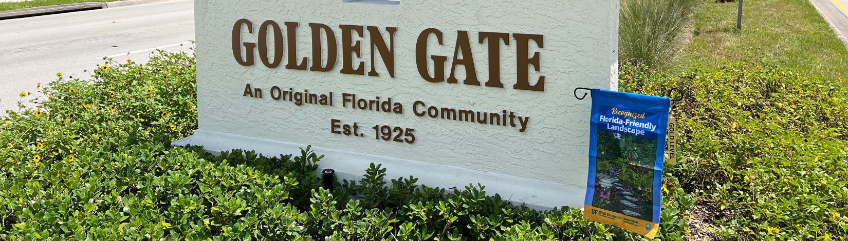 Golden Gate community marker sits within the roadway median recognized as a Florida-Friendly Landscaping Gold project. The recognition flag is displayed.