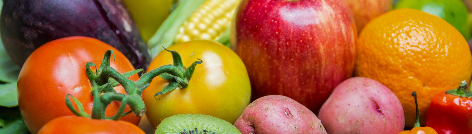 An assortment of tomatoes, apple, orange, eggplant, corn, kiwi, potatoes, and a bell pepper.