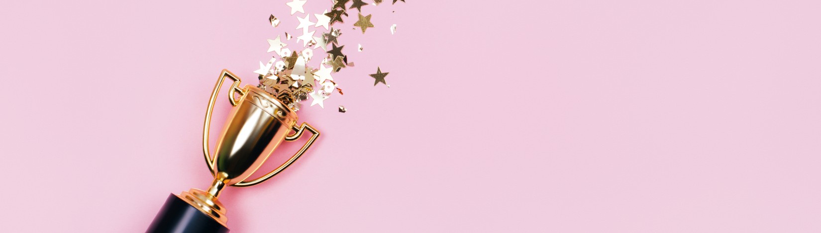 One winners cup with golden sparkles on a pastel background. Banner with copy space. Flat lay style.