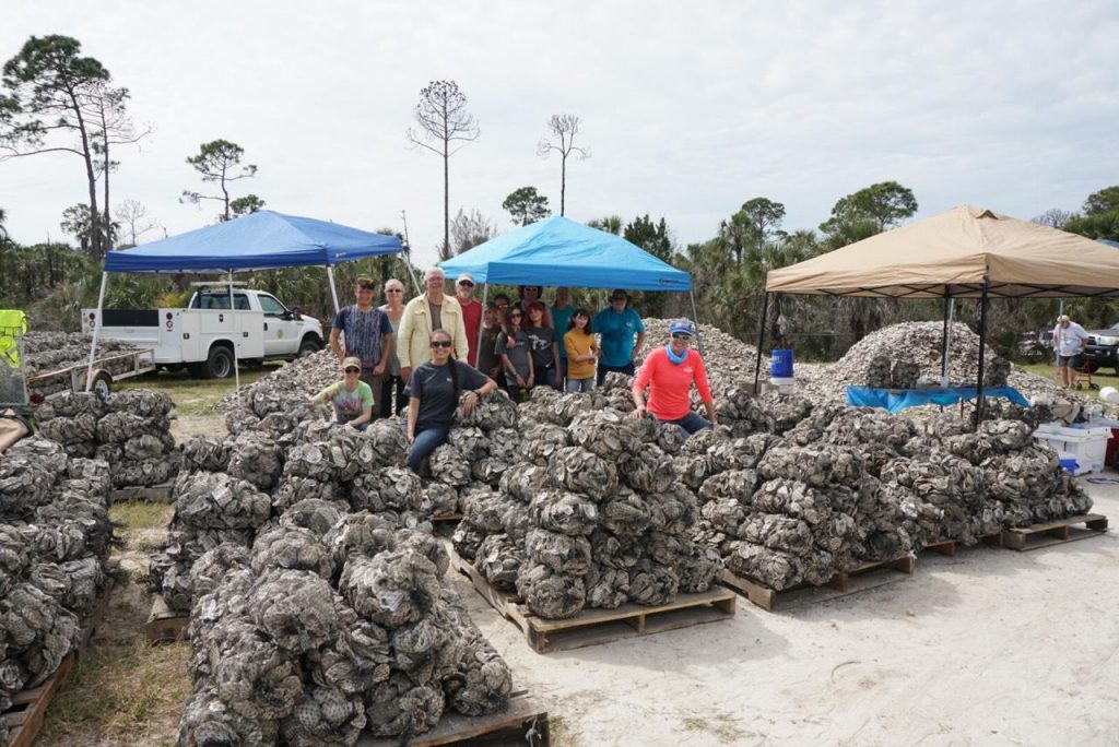 Volunteers and project team members pose with bagged oyster shell.