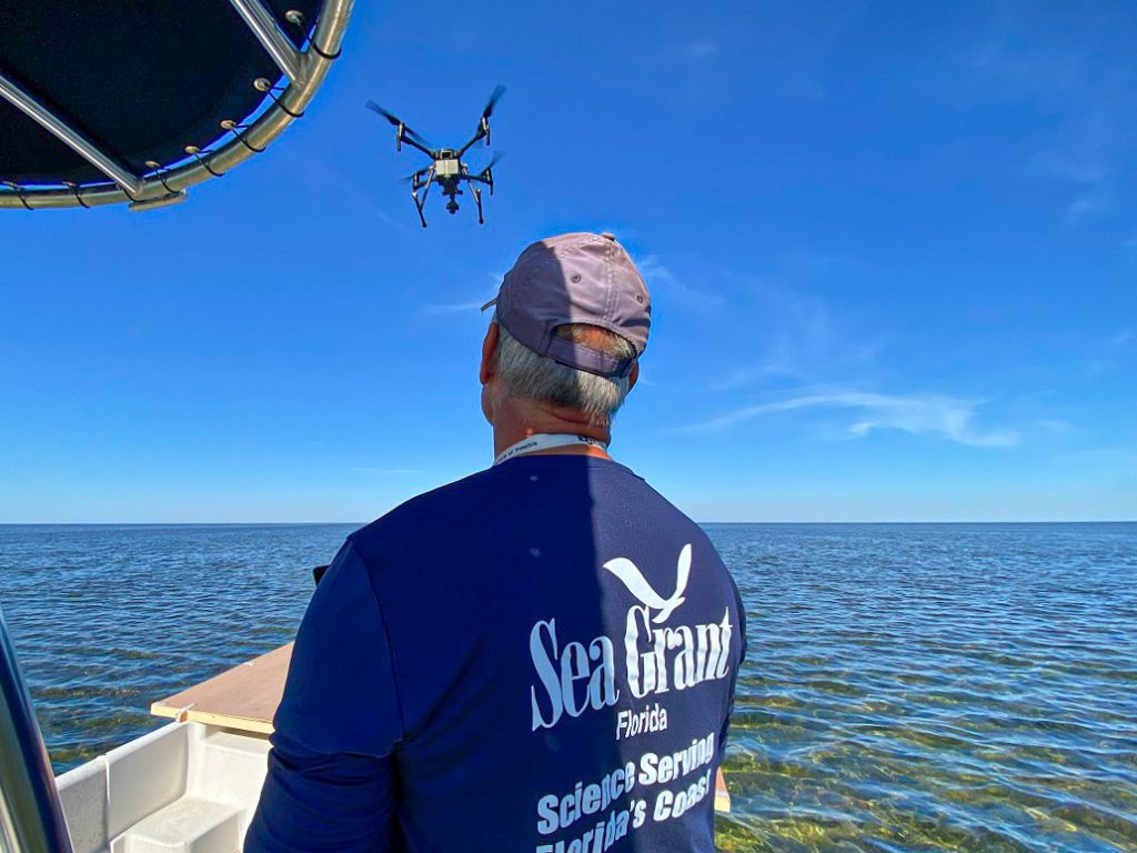 man piloting a drone over water