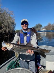 (Left) Kyle Williams (UF undergraduate) holds a stunned Snook collected in Suwannee River with electrofishing.