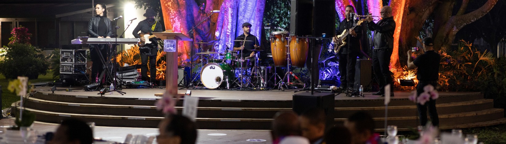 A band performing on an outdoor stage at night