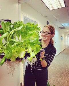 Lorna Bravo holding a large head of lettuce indoors
