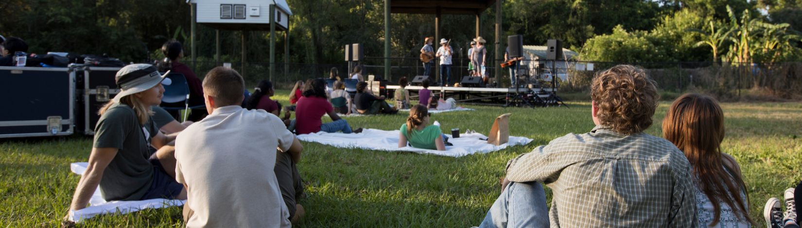 People watching a concert in front of the bat houses at the Horticultural Sciences Spring Festival.