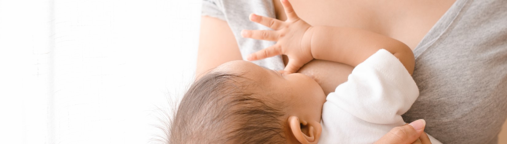 Mother holding and breastfeeding her baby