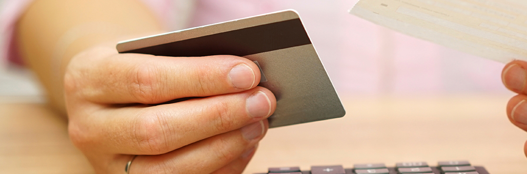 Woman holding credit card and bill