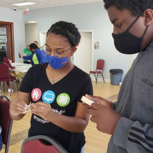 4-H educator helping a 4-H youth member with an activity