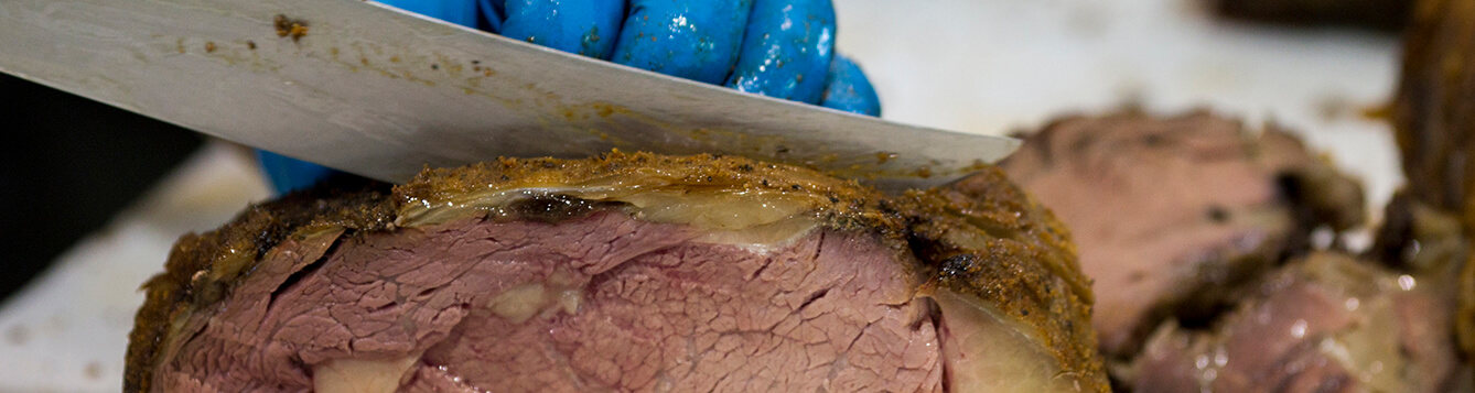 Knife cutting roasted meat