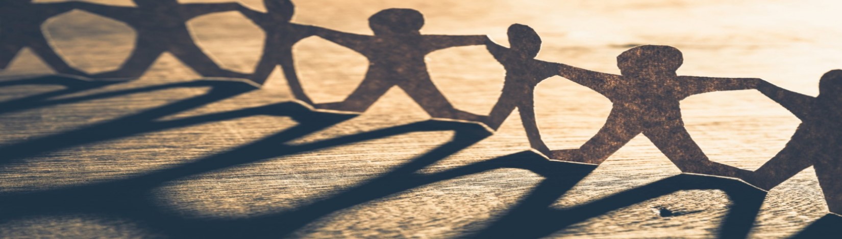 Human paper cutouts holding hands in a row