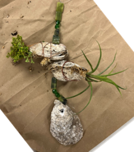 a plant vog with two plants added between the shells and green decorative beads