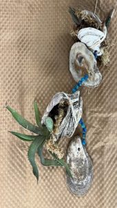 a plant vog with two plants added between the shells and blue decorative beads