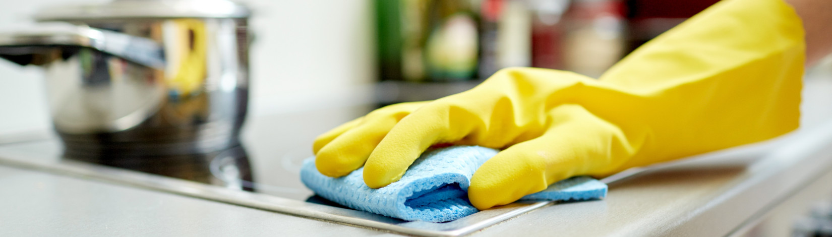 close up of woman cleaning cooker at home kitchen.