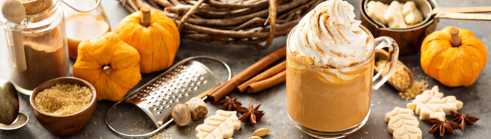 Pumpkin spice latte in a glass mug.