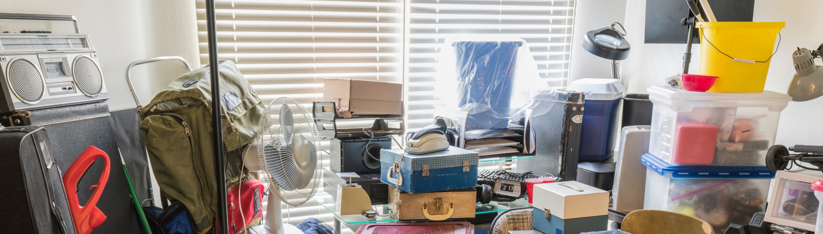 Hoarder room packed with boxes, electronics, business equipment, household objects and miscellaneous junk.