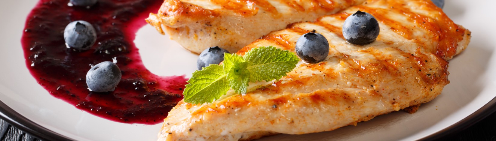 Summer fitness food: Grilled chicken fillet with blueberry sauce and mint closeup. horizontal.