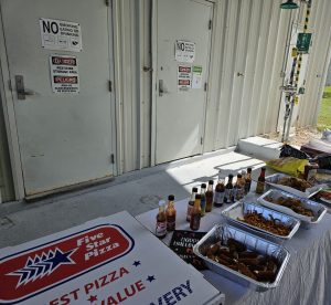 Food table set up next to pesticide storage clearly saying "no food or drinks"