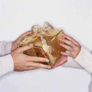 Hands Exchanging Wrapped Gift